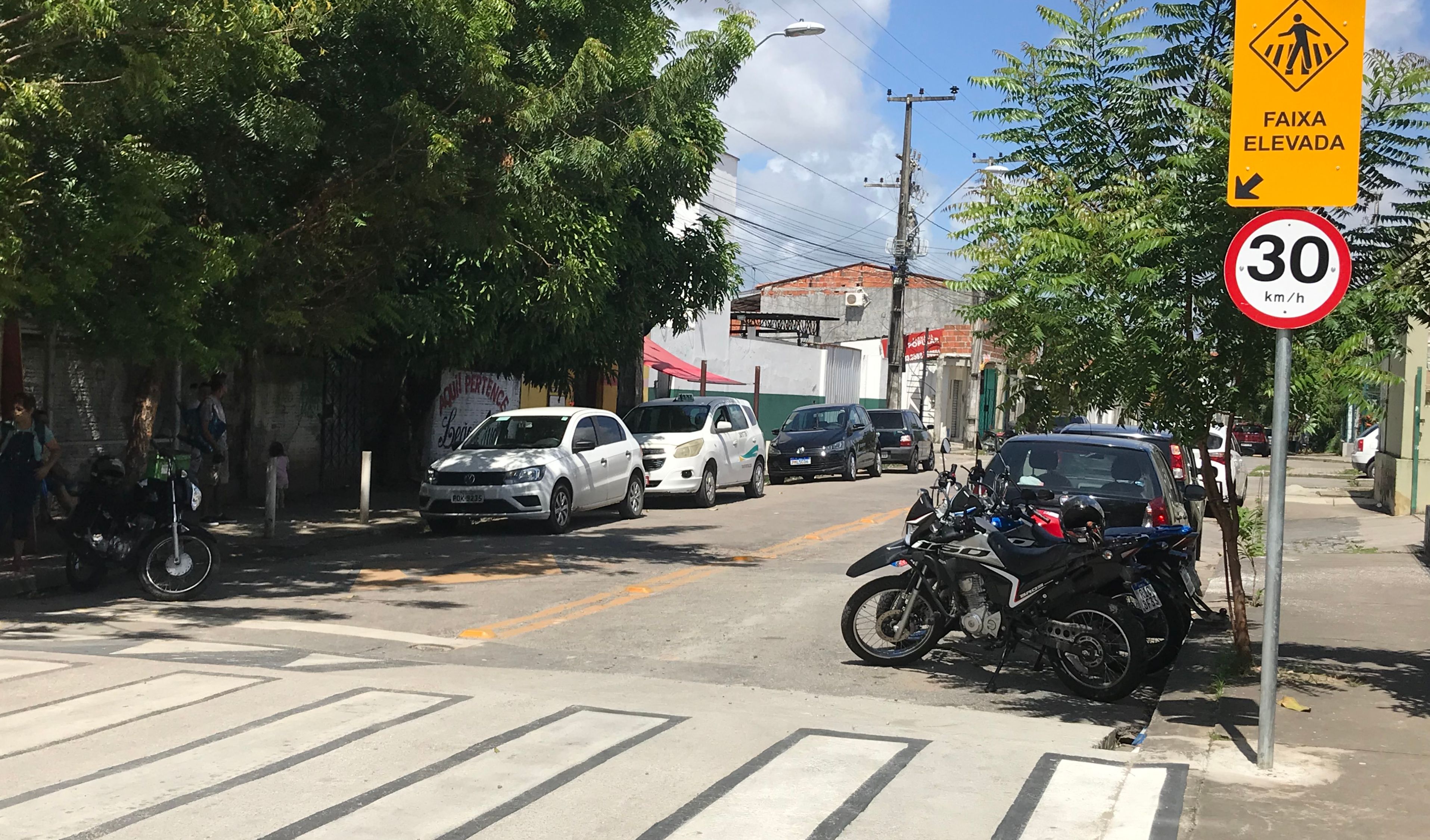 a foto mostra uma rua com uma faixa de pedestre